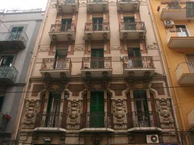 Foto 11. Ancora pi� ricco e brioso � l�edificio di fronte a quest�ultimo: di colore marrone e beige, presenta al primo piano decori floreali, con balconi a forma di trapezio sotto cui seminascosti si trovano pittoreschi mascheroni 